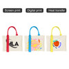Three horizontal canvas tote bags in cream featuring various designs: one with a red handle, one with a blue handle, and one with a yellow handle.