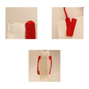 A horizontal canvas tote bag in cream with red handles and a logo. Multiple angles highlight its design.