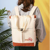 A beige convertible nylon backpack with brown accents and a logo, worn on a person’s back against a colourful background.