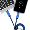 A blue 3-in-1 charging cable connects a laptop to a mobile phone displaying a charging status.