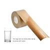 A roll of water-activated reinforced kraft paper tape in brown, alongside a glass of water.