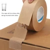 A roll of brown kraft paper tape is being applied to a cardboard box, showcasing its texture and water activation feature.