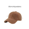 A brown 6 panel lamb fur baseball cap with an adjustable size feature and a curved brim. It has a logo on it.