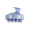 A lavender hair scalp massager with soft, pointed bristles and a sturdy handle. It has a speckled design.
