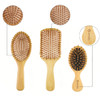Three bamboo combs in various sizes and shapes, featuring natural wood finishes and rubber bristles. One includes a logo.