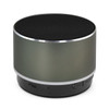 A round Bluetooth speaker in matte grey with a black speaker grill and a silver trim, featuring a branding logo.