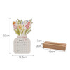 A flowers-themed desk calendar features a floral design on top, with a wooden base for support.
