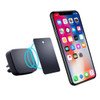A black magnetic car mount next to a smartphone displaying various apps, with a metal plate nearby.