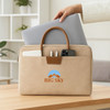 A beige suede PU leather laptop bag with brown handles and compartments for a laptop, phone, and other accessories.