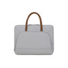 A grey laptop bag with a zippered outer pocket and brown PU handles, featuring a simple and sleek design.