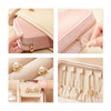 A velvet jewellery box in cream and pink with compartments, showcasing earrings and storage for various accessories.