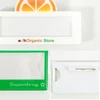 A custom reusable acrylic name badge in white and green, featuring a logo and a pin attachment.