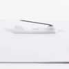 A white PVC name badge with a safety pin attachment on the back.