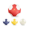 A red and white handball with a logo, surrounded by a yellow, navy, and white handball.