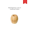 A bamboo toothbrush stand with a circular opening, featuring a logo engraved on the side.