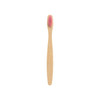 A small bamboo toothbrush with a pink bristle head and a smooth bamboo handle. It has a simple logo on the base.