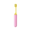 A foldable soft bristle toothbrush in pink and yellow, featuring a compact design for easy storage.