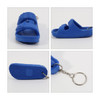 A blue keyring shaped like a pair of sandals, featuring a silver keychain attachment and a textured sole.
