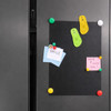 Brightly coloured thong-shaped fridge magnets on a black board with assorted notes attached.
