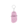 A pink clog shoe keyring features detailing like holes and a strap, attached to a metal chain. It has a logo.