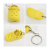 A yellow clog shoe keyring featuring decorative cut-outs and a silver keyring attachment. Includes a textured sole design.