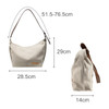 A beige canvas tote bag with a brown strap, featuring a logo, measuring 51.5–76.5 cm in length and 29 cm in height.