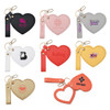 A collection of heart-shaped compact mirrors in various colours, featuring keychains and distinct logos.