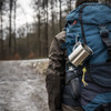A backpack with a silver mug attached using a D Type aluminium alloy carabiner hook in a forested setting.