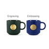 A green ceramic mug with a bronze medal and a blue ceramic mug with a bronze medal, both featuring ribbed designs.