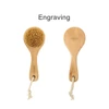 A round body brush with a short wooden handle and natural bristles, featuring a rope for hanging.