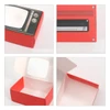 A red gift box designed like a retro TV, featuring an open lid and classic knob decorations.