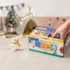 A colourful multi-compartment box with various playful emoji designs and a small white teddy bear beside it.