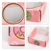A small pink gift box featuring a round window and a playful donut print. The box has a logo and is rectangular in shape.