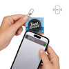 A person's hands hold an NFC acrylic spinning keychain, featuring a round black design, above a smartphone displaying content.