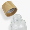 A drink bottle made of glass, featuring a bamboo lid, showcasing a clear design.
