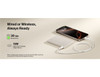 A slim white power bank with a USB-C connection, placed beside a smartphone. The power bank has branding.