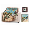 A tapestry blanket featuring a camping scene with mountains, trees, and a retro caravan, in earthy tones.