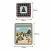 A tapestry blanket featuring a Christmas tree design and a camping scene with mountains and a caravan, in green and beige tones.