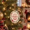 A ceramic ornament featuring festive colours and designs, hanging on a decorated Christmas tree.