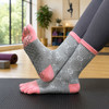 Crew custom sport toe socks in grey and pink, featuring a patterned design and a logo, displayed on a yoga mat.