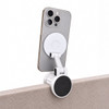 A white Tutor Maglock phone holder attached to the edge of a surface, holding a smartphone securely in place.