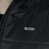 A close-up of a black puffer vest featuring a logo. The fabric appears smooth and insulated.
