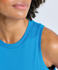 A close-up of a woman's shoulder and neckline wearing a blue tank top with a round neckline and a smooth fabric.