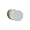 A grey mini tin candle with a white wax interior and a wick, displayed with the lid off.