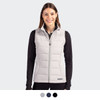 A woman wearing a light grey puffer vest with a zip front. The vest has a logo and is styled with a black top.