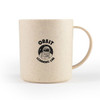 A cream-coloured reusable mug made from wheat fibre, featuring a logo with an astronaut design.