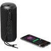 A black rugged fabric waterproof Bluetooth speaker beside a smartphone displaying a music app.