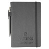 A grey notebook with a pen attached, featuring a textured cover and an elastic band closure.