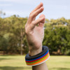 A hand wearing a wrist disc silicone flyer with colorful, flexible rings stacked on the wrist.