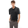 A black polo shirt worn by a model, featuring a collar and short sleeves. The model is paired with grey trousers.